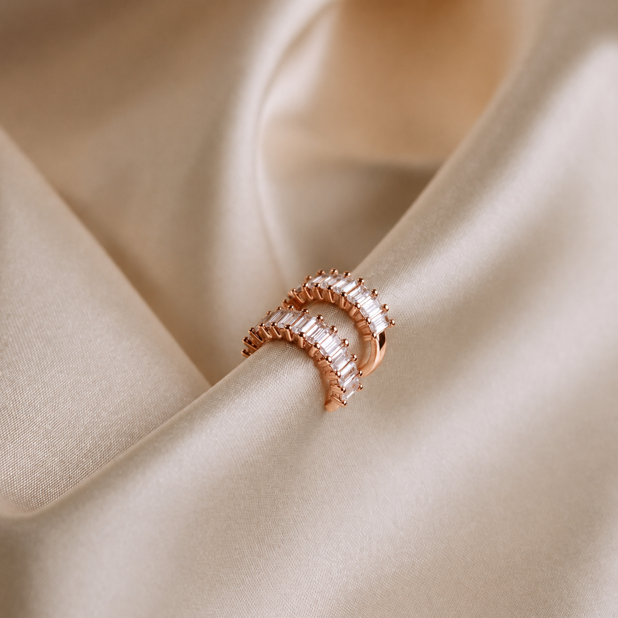 Rose gold ring on beige satin fabric