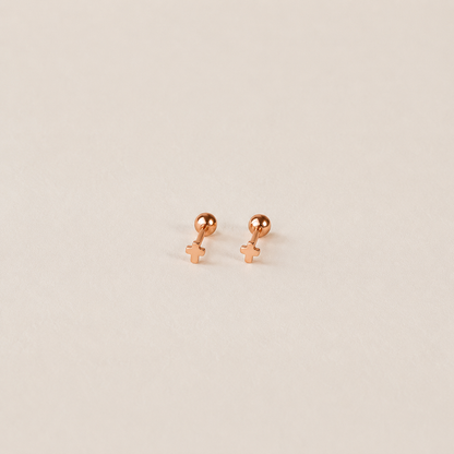 Rose gold earrings on a beige background
