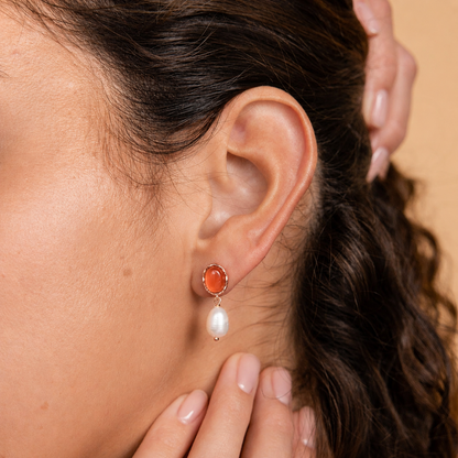 Close-up of a woman wearing a earrings with a brown background