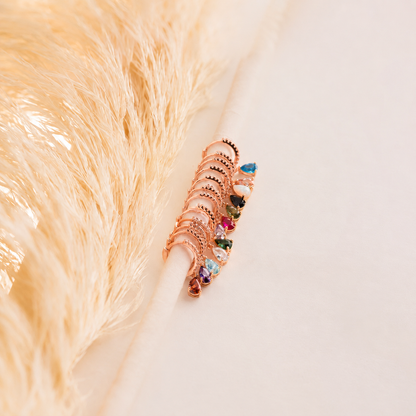 Rose gold hair clip with colorful gemstones on a soft beige background