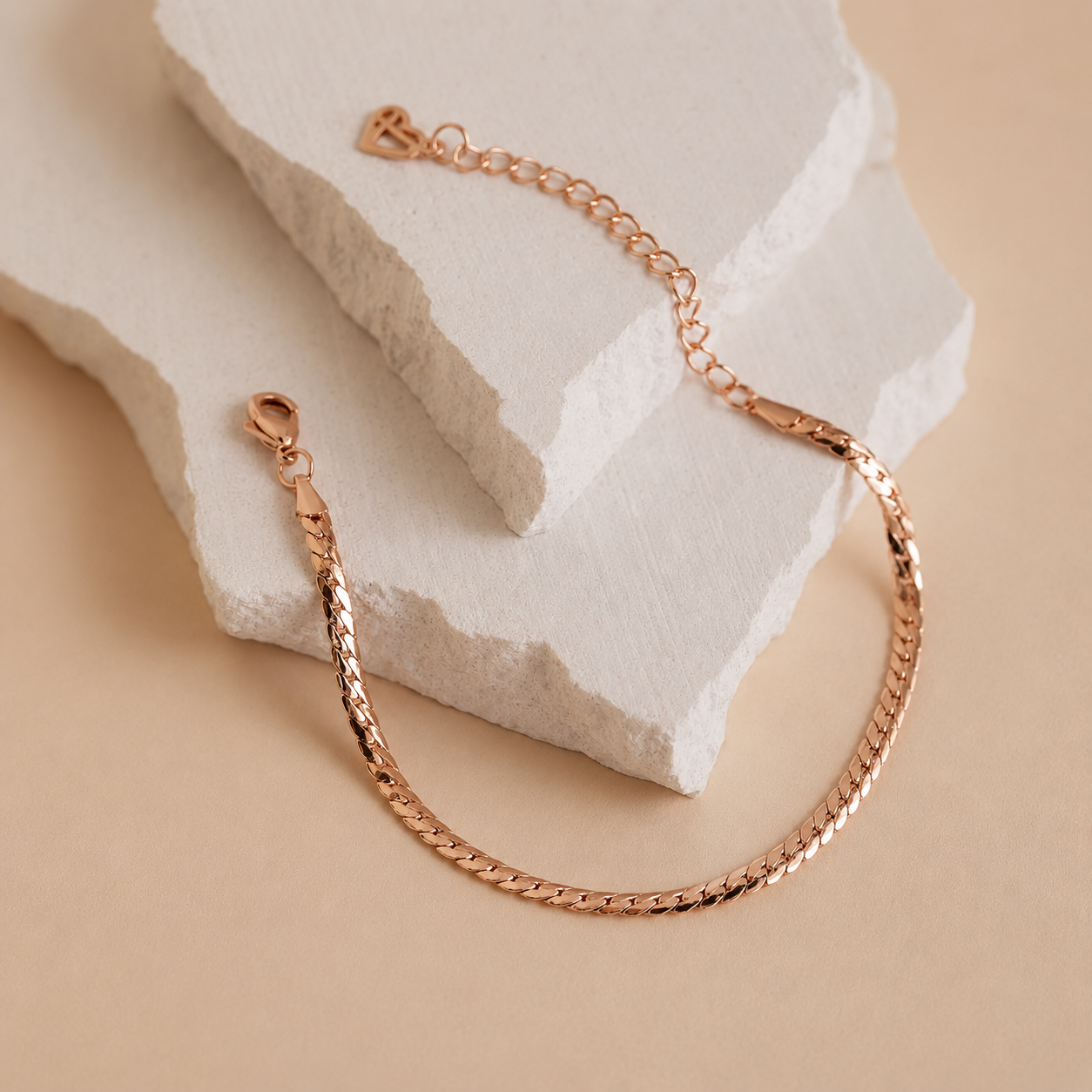 Rose gold bracelet on a textured beige surface