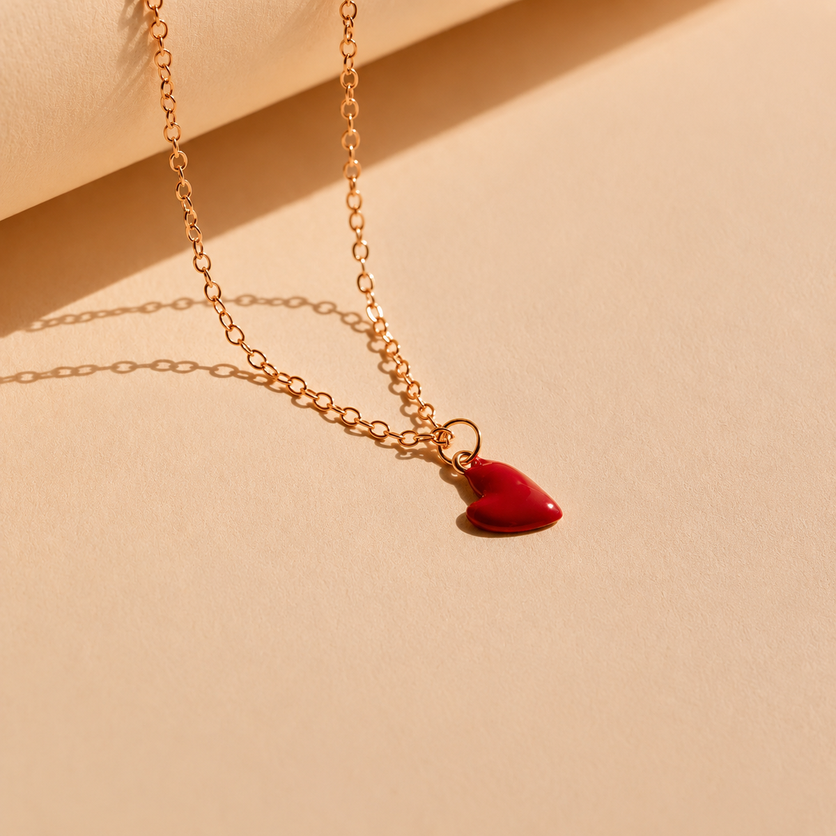 Necklace with a red heart pendant on a beige background