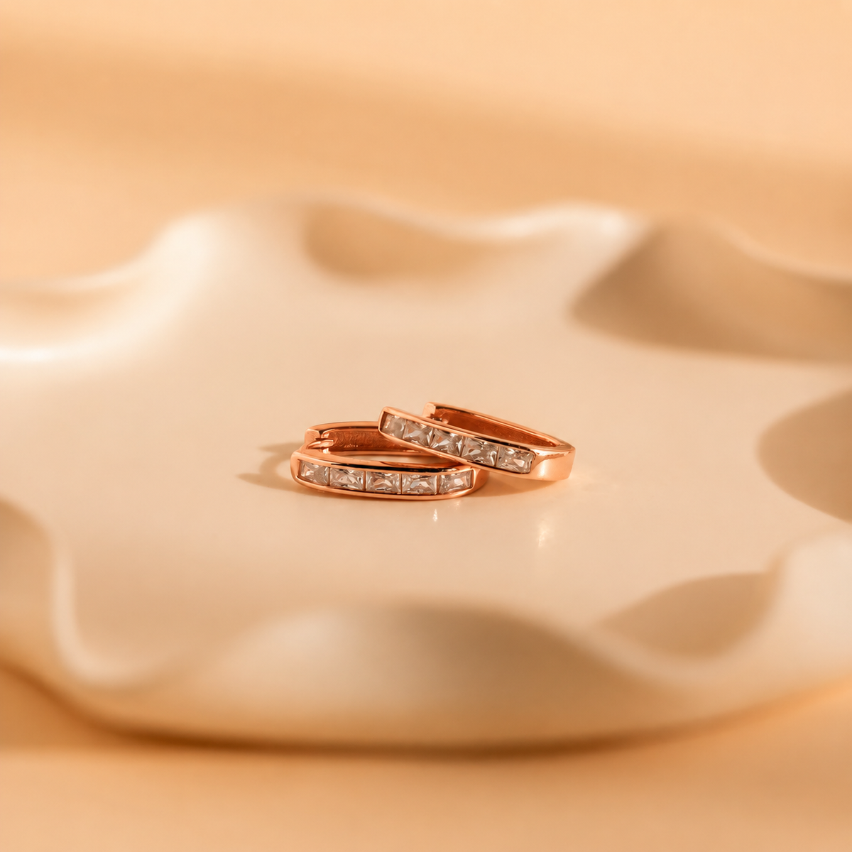 Rose gold ring with embedded diamonds on a beige ceramic dish