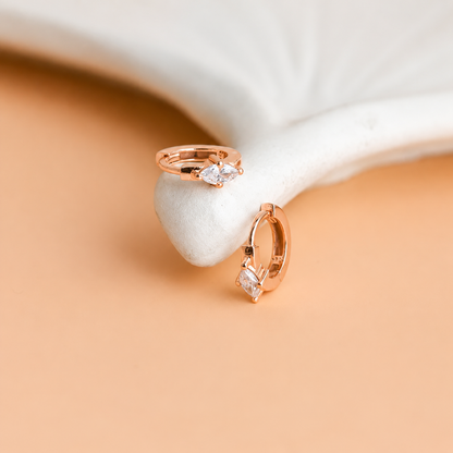 Rose gold ring with gemstones on a white stone surface