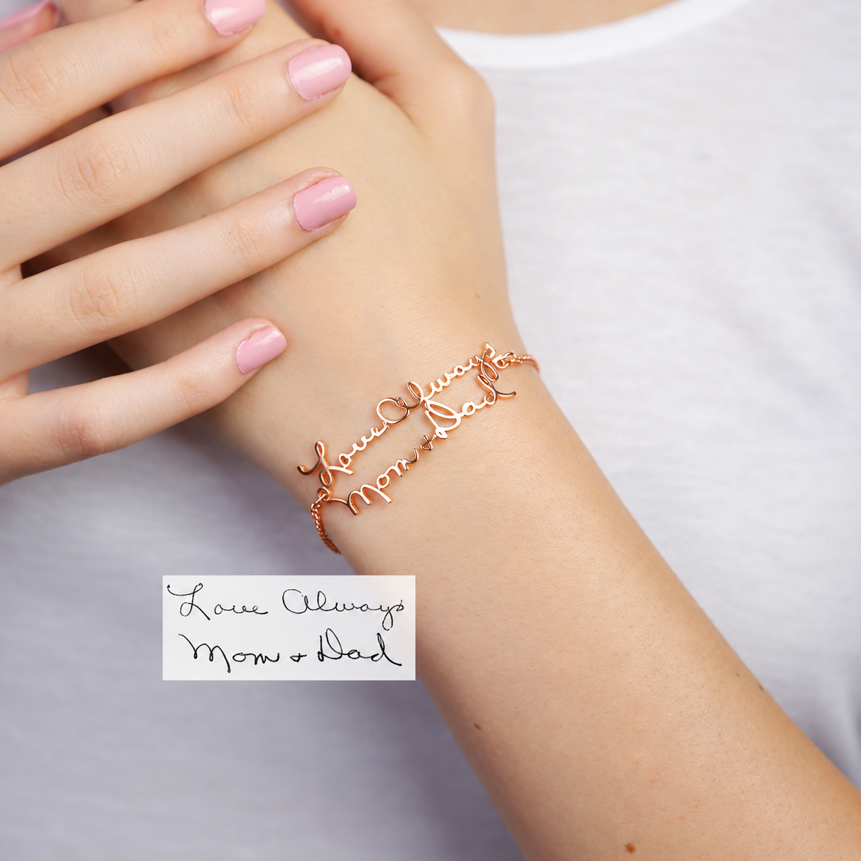 Rose gold bracelet on a wrist with a white card below