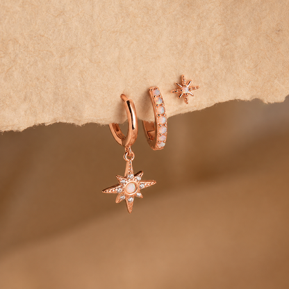 Rose gold star-shaped earrings on a textured brown background