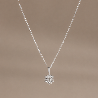 Silver necklace with a flower-shaped pendant on a beige background