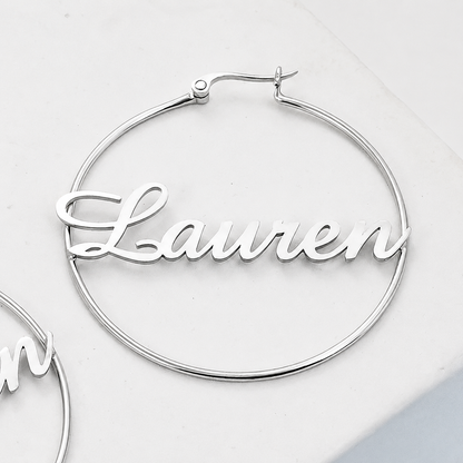 Silver hoop earrings with 'Lauren' engraving on a light gray background