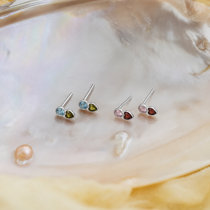Set of small stud earrings with multicolored gemstones on a shell background