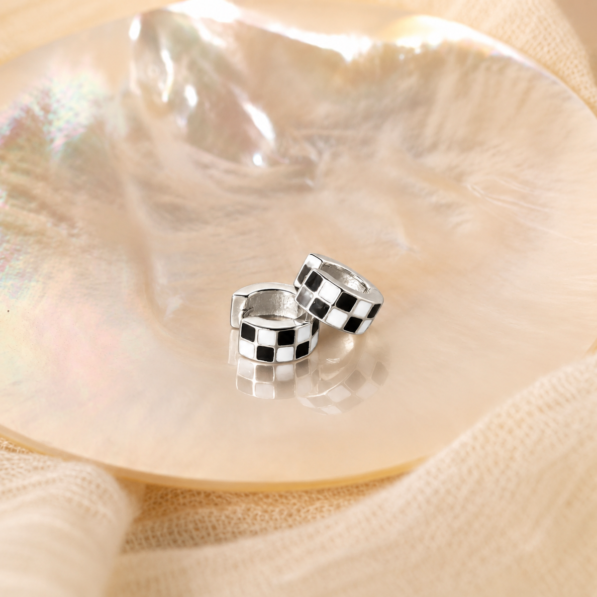 Silver hoop earrings on a seashell