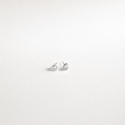 A pair of silver stud earrings with pear-cut clear gemstones, displayed on a clean white background.