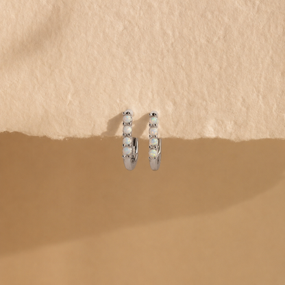 Silver hoop earrings on a beige background