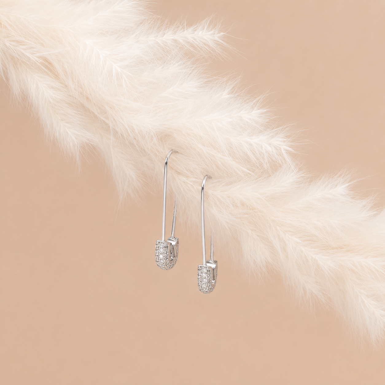 Silver earrings on a fur surface with a neutral background