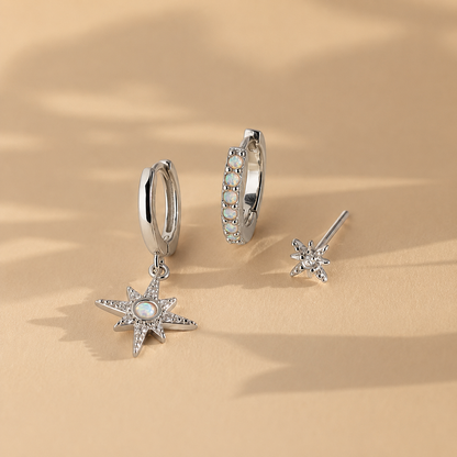 Silver star-shaped earrings on a beige background