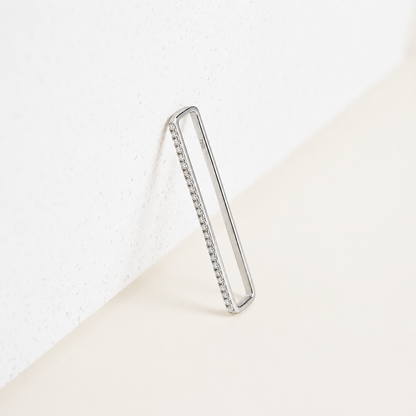 Silver hoop earring with embedded stones on a white background