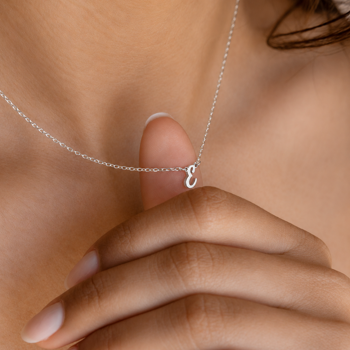 Silver necklace with a heart pendant worn by a person