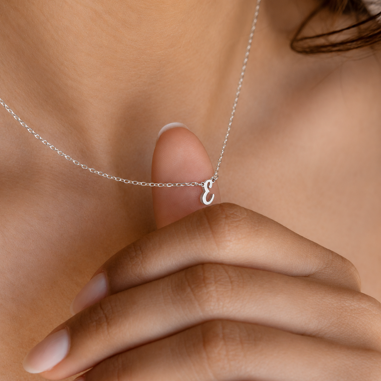 Silver necklace with a heart pendant worn by a person