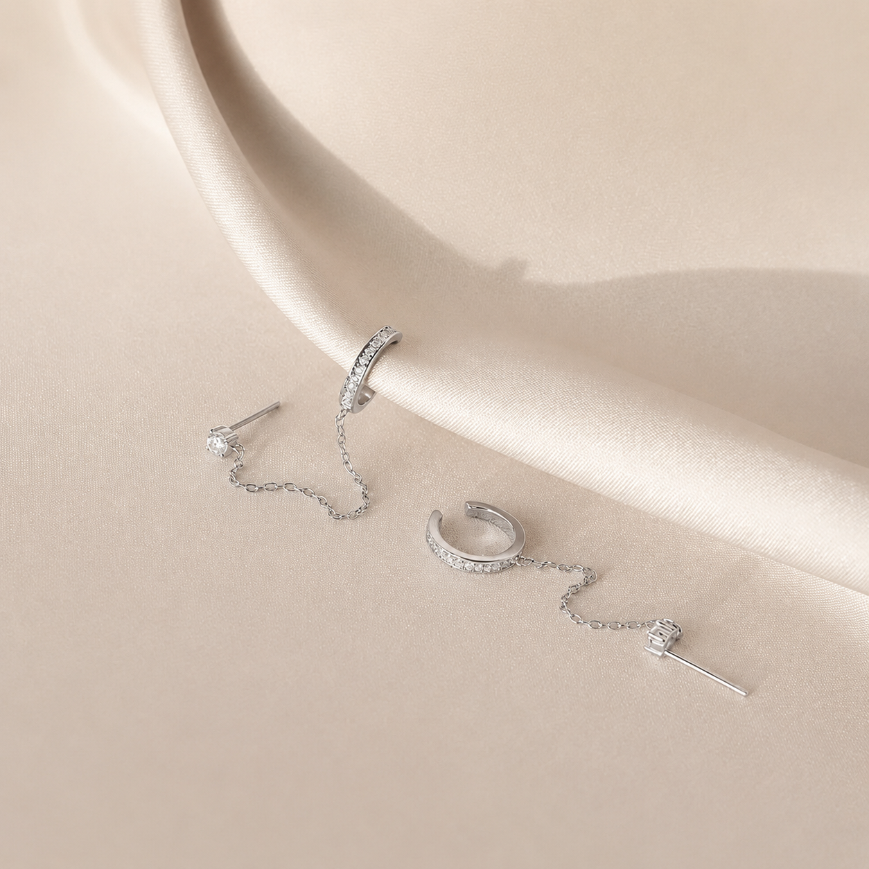 Silver jewelry set on a beige surface