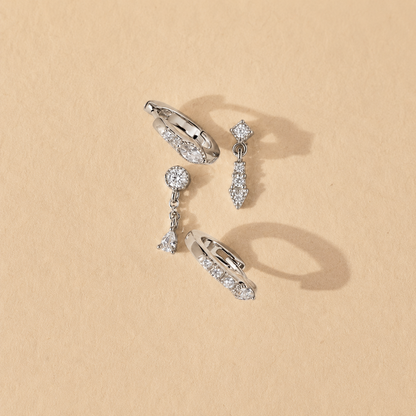 Set of silver earrings on a beige background
