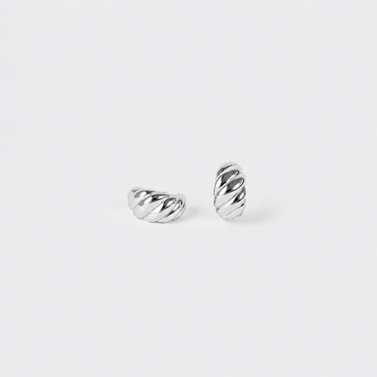 A pair of silver twisted cable hoop earrings on a clean, light gray background.