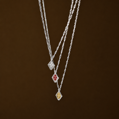 Silver necklace with three pendant drops on a brown background