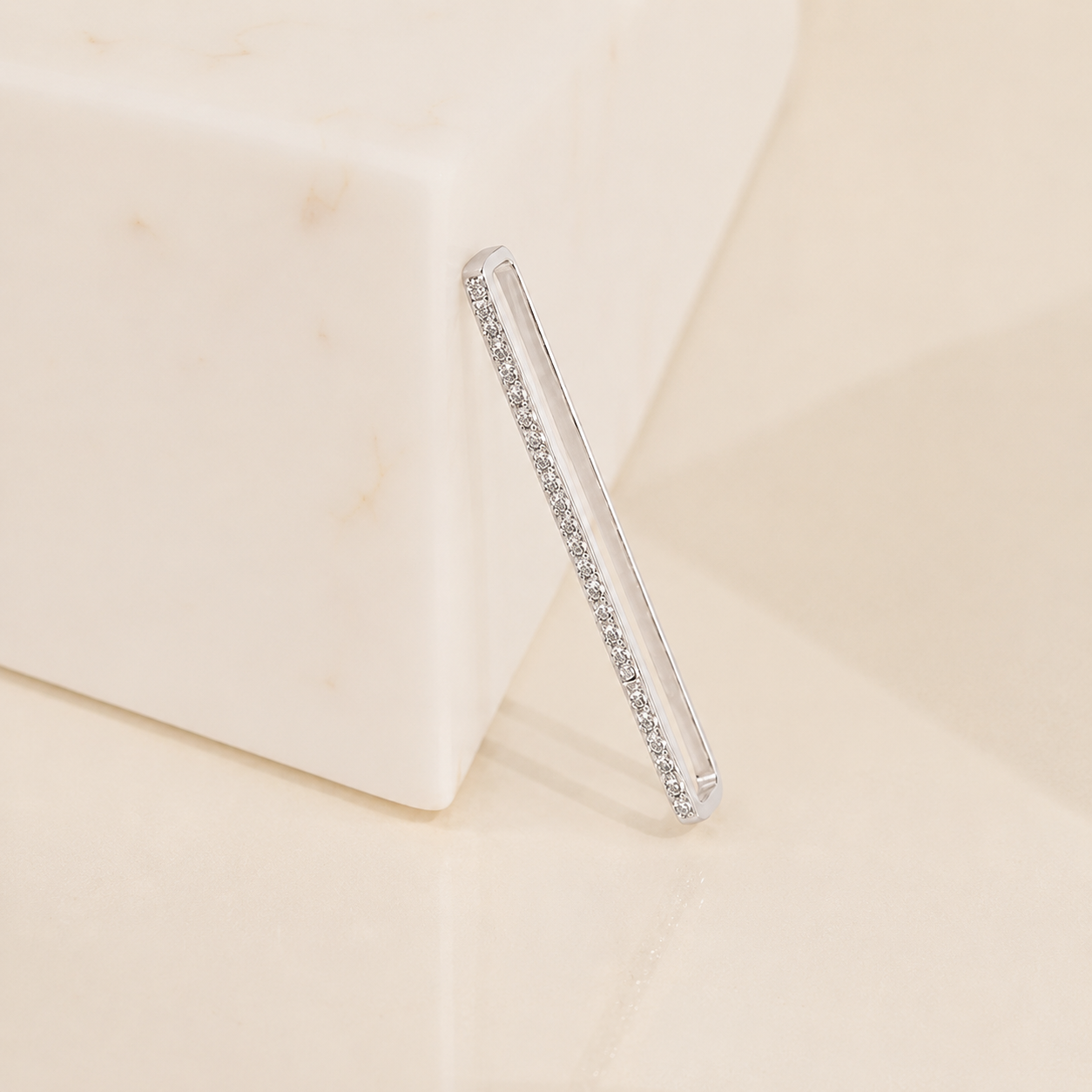 Clear hair straightener with embedded rhinestones on a beige background