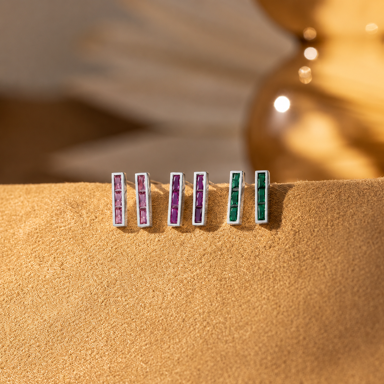 Set of earrings with colorful gemstones on a textured surface