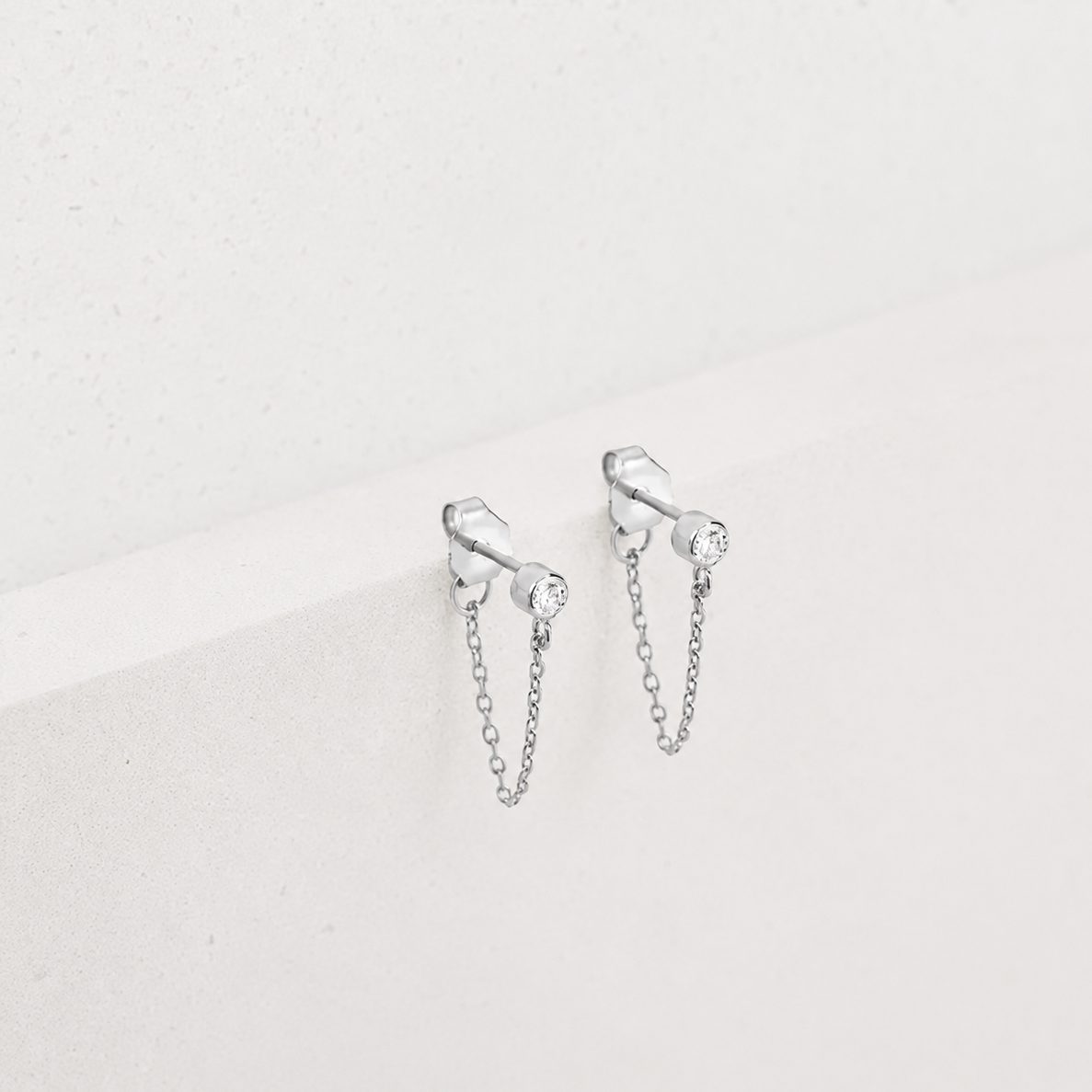 Silver chain earrings on a light gray background