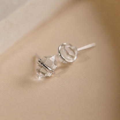 Crystal stud earrings on a beige background