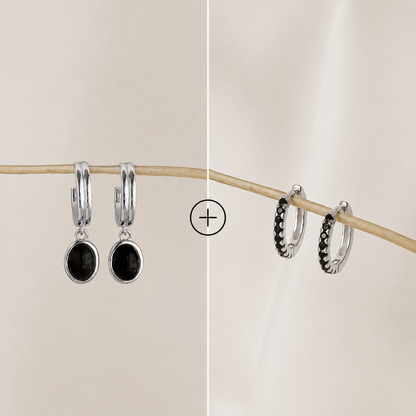 Two pairs of hoop earrings with black stones on a beige background