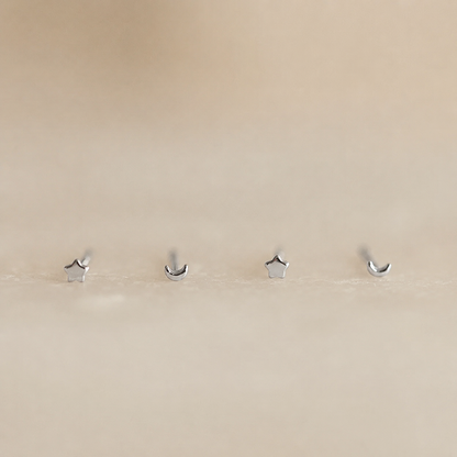 Four silver hooks on a beige wall