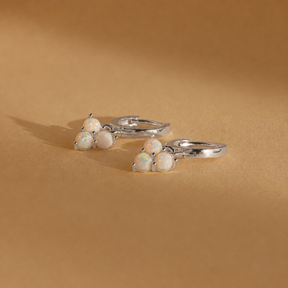 Silver rings with opal stones on a beige background