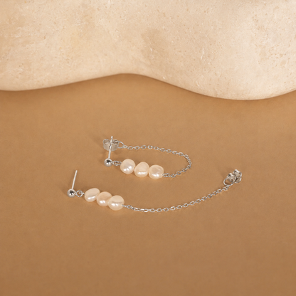 Pearl earring on a beige background