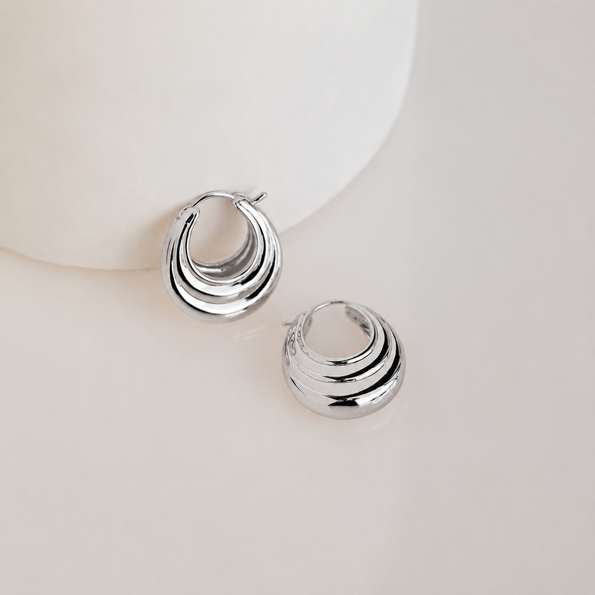 Pair of silver hoop earrings on a light background