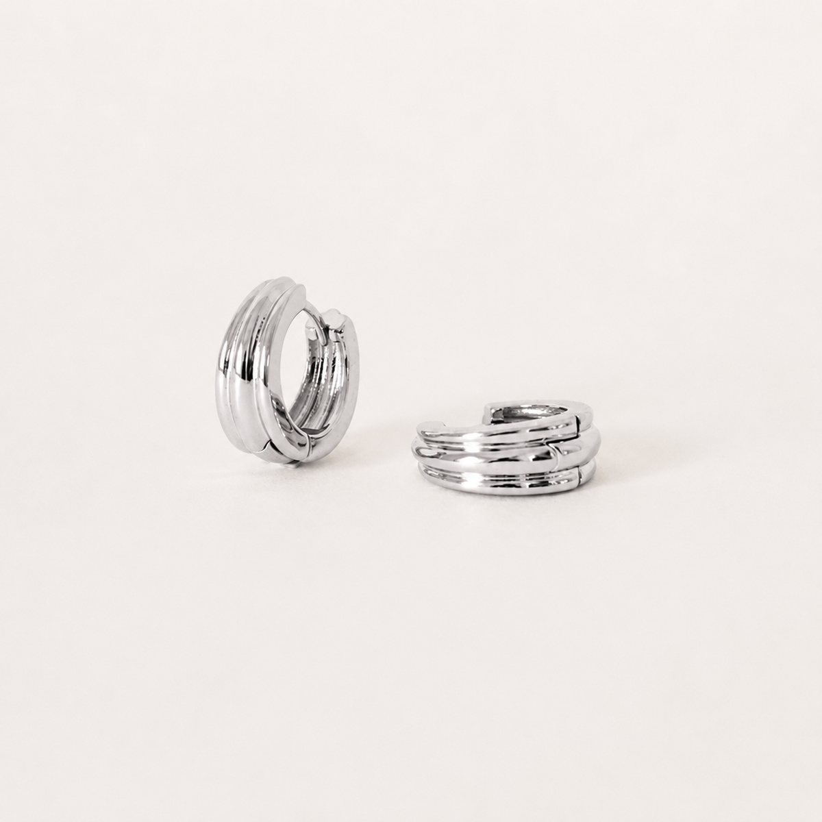 Silver hoop earrings on a light beige background