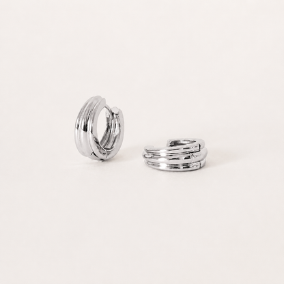 Silver hoop earrings on a light beige background