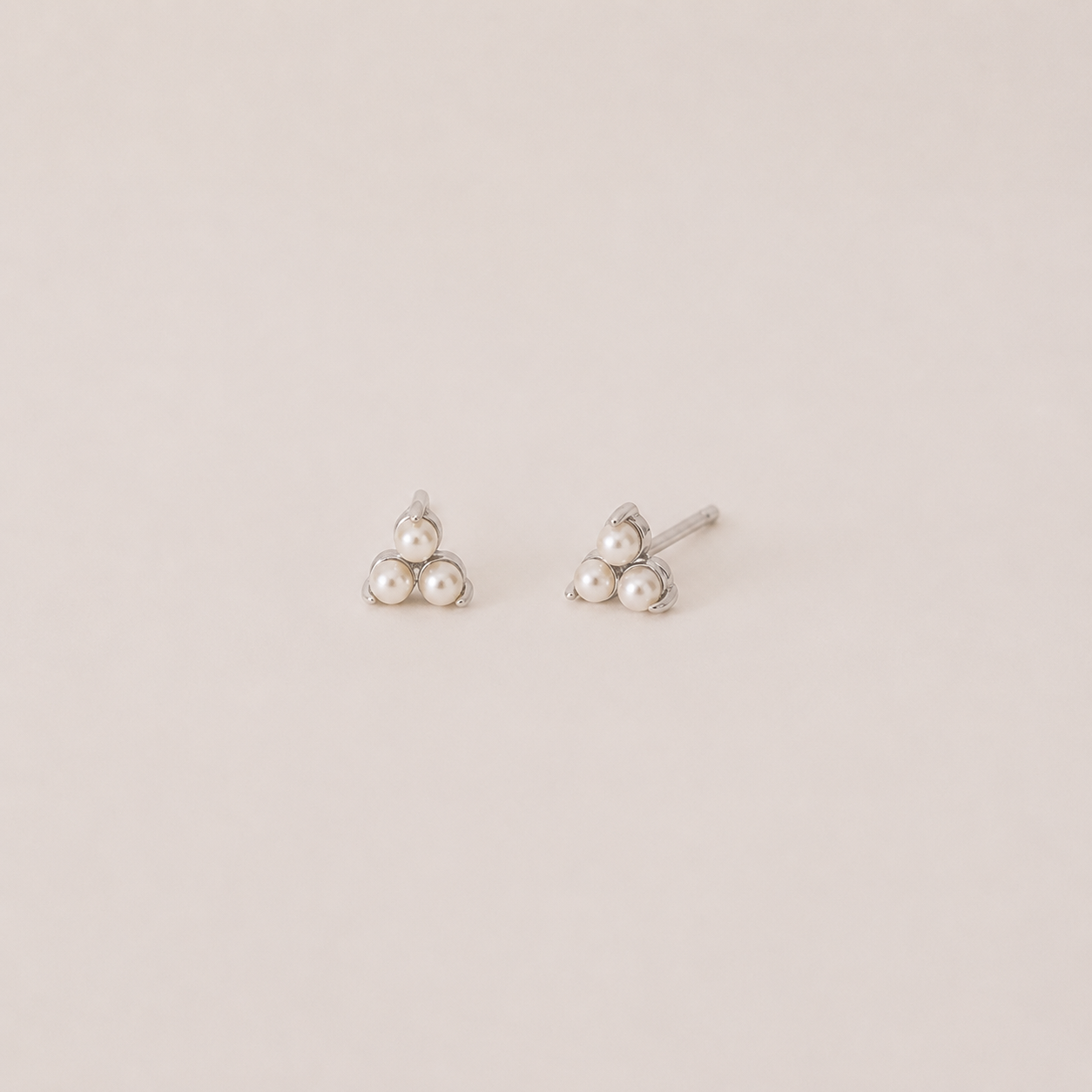 Pair of pearl earrings on a light beige background