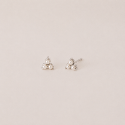 Pair of pearl earrings on a light beige background