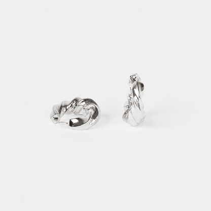 A pair of polished silver twisted hoop earrings shown from two angles on a light gray background.