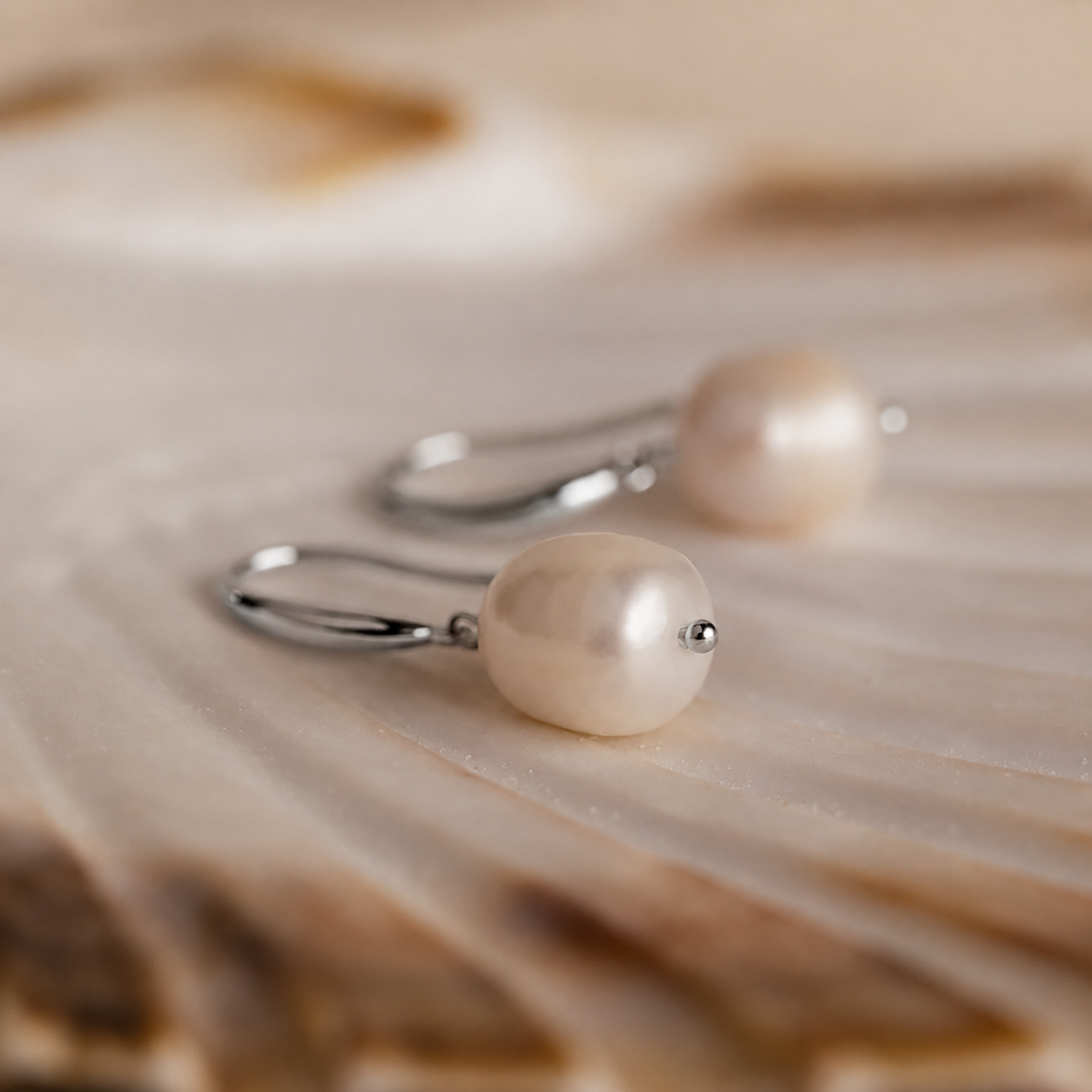 Pearl earrings on a wooden surface