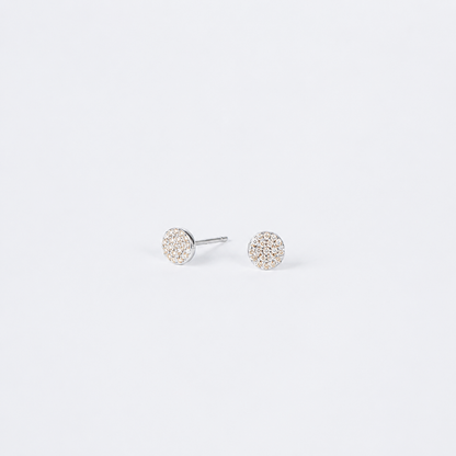 A pair of round stud earrings with pavé-set clear stones in a silver-tone setting, shown on a plain light gray background.