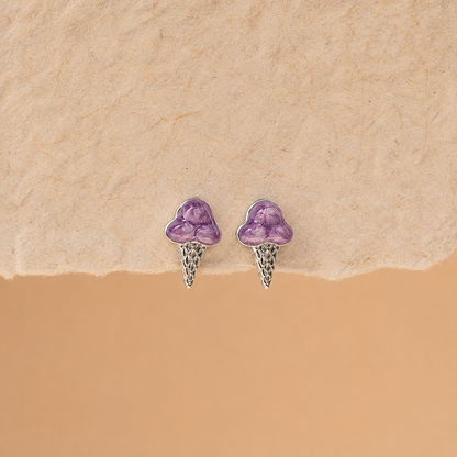 Pair of purple heart-shaped earrings on a beige background