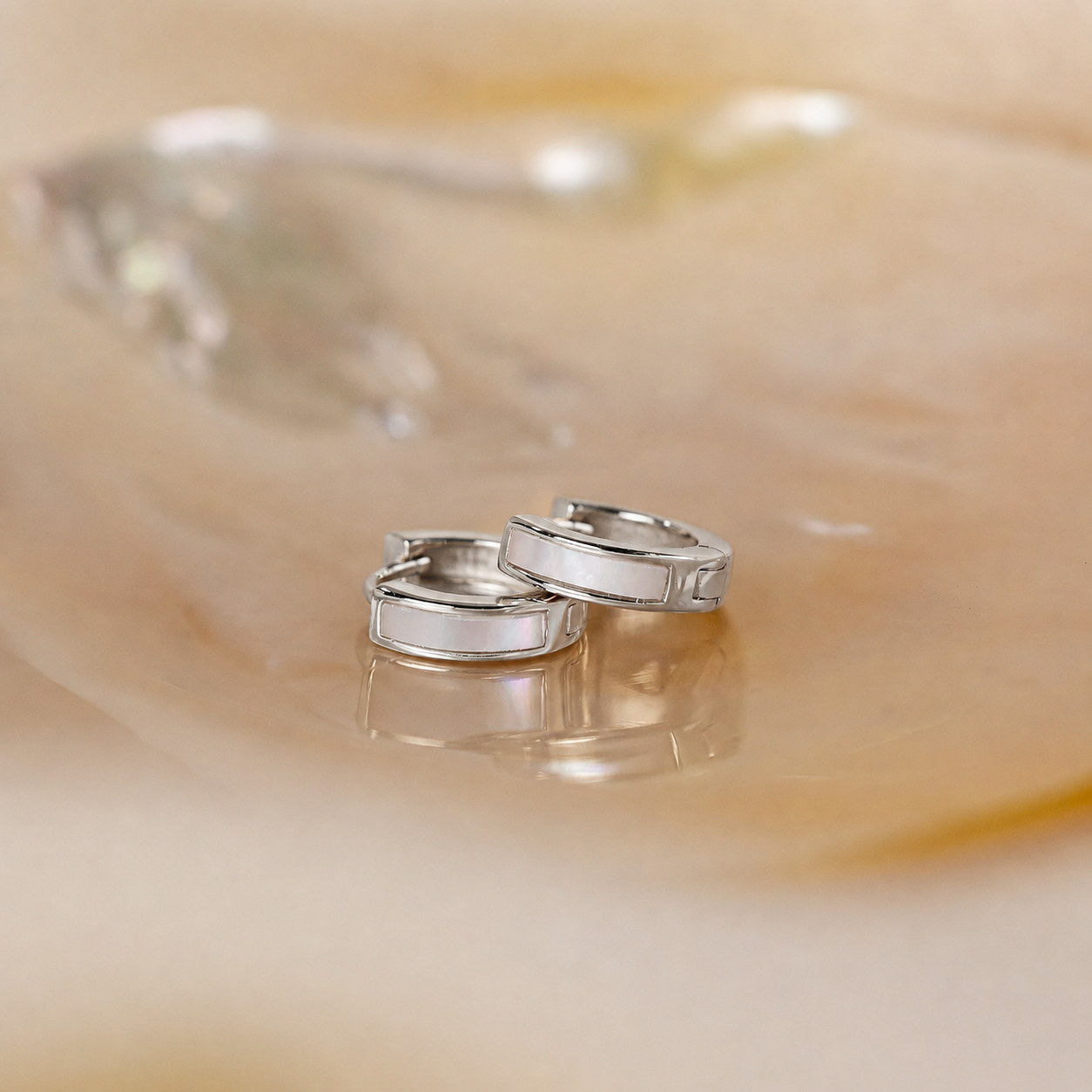 Two silver rings on a smooth, beige surface