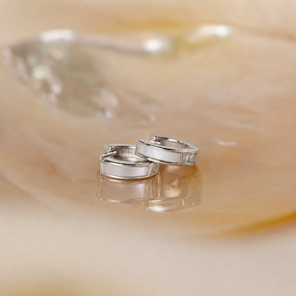 Two silver rings on a smooth, beige surface