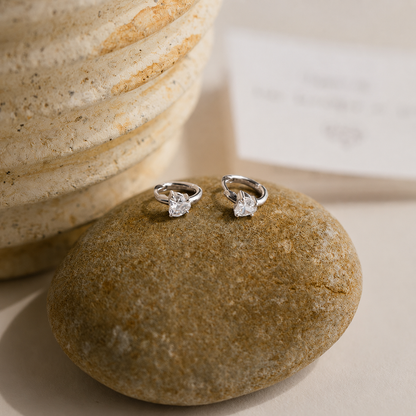 Pair of diamond earrings on a stone surface
