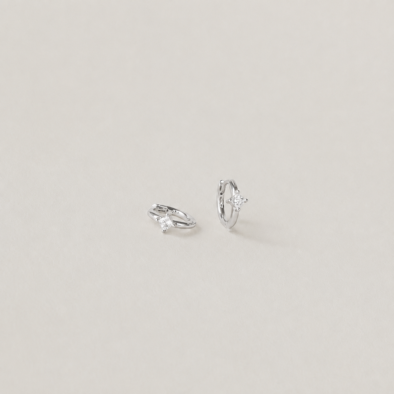 Pair of silver hoop earrings on a light gray background