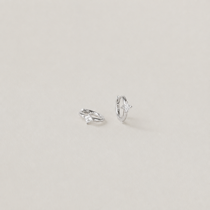 Pair of silver hoop earrings on a light gray background