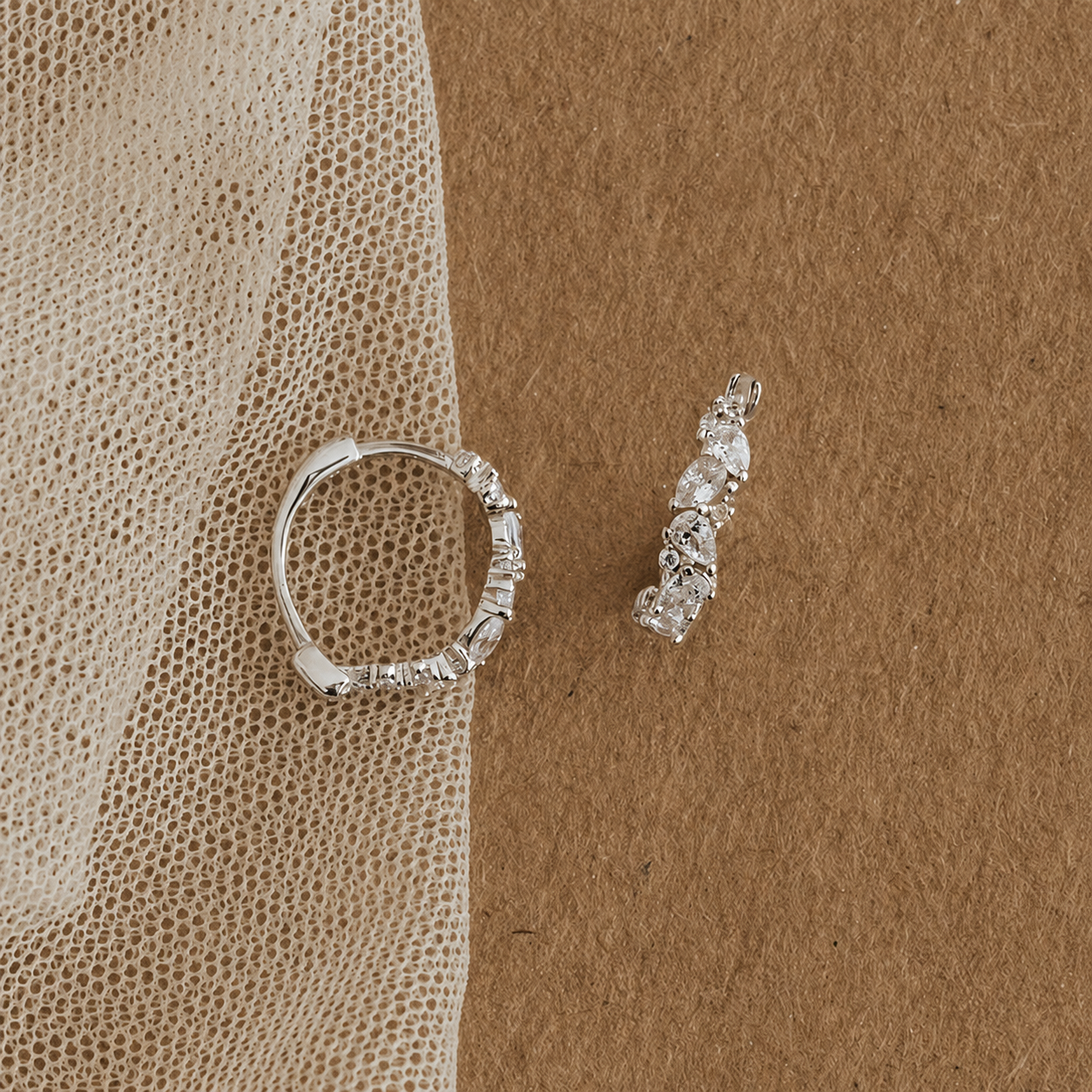 Silver ring and earrings on a textured brown surface