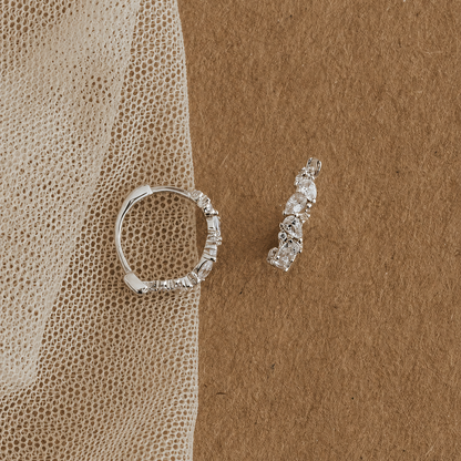 Silver ring and earrings on a textured brown surface