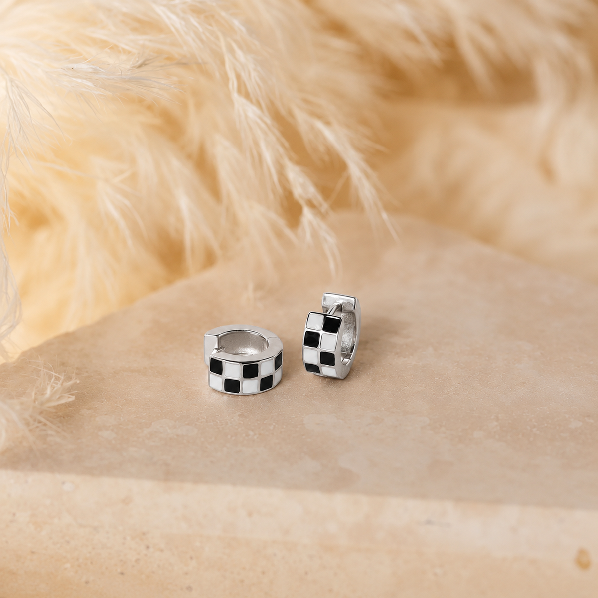 Checkered hoop earrings on a fur surface